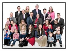 Familie fotoshoot binnen van 26 personen met kleurrijke kleding zittend en staand in witte omgeving gefotografeerd in fotostudio Rotterdam. www.marijnissenfotografie.nl
