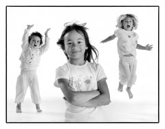 Kinderfotoshoot van drie spelende kinderen met witte kleding in witte omgeving  gefotografeerd door fotograaf in de fotostudio. www.marijnissenfotografie.nl