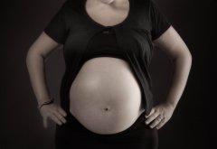 Zwangerschapsfotografie met zwarte rok en topje met korte mouwtjes waardoor de zwangerschapsbuik mooi uitkomt gefotografeerd in fotostudio Rotterdam. www.marijnissenfotografie.nl